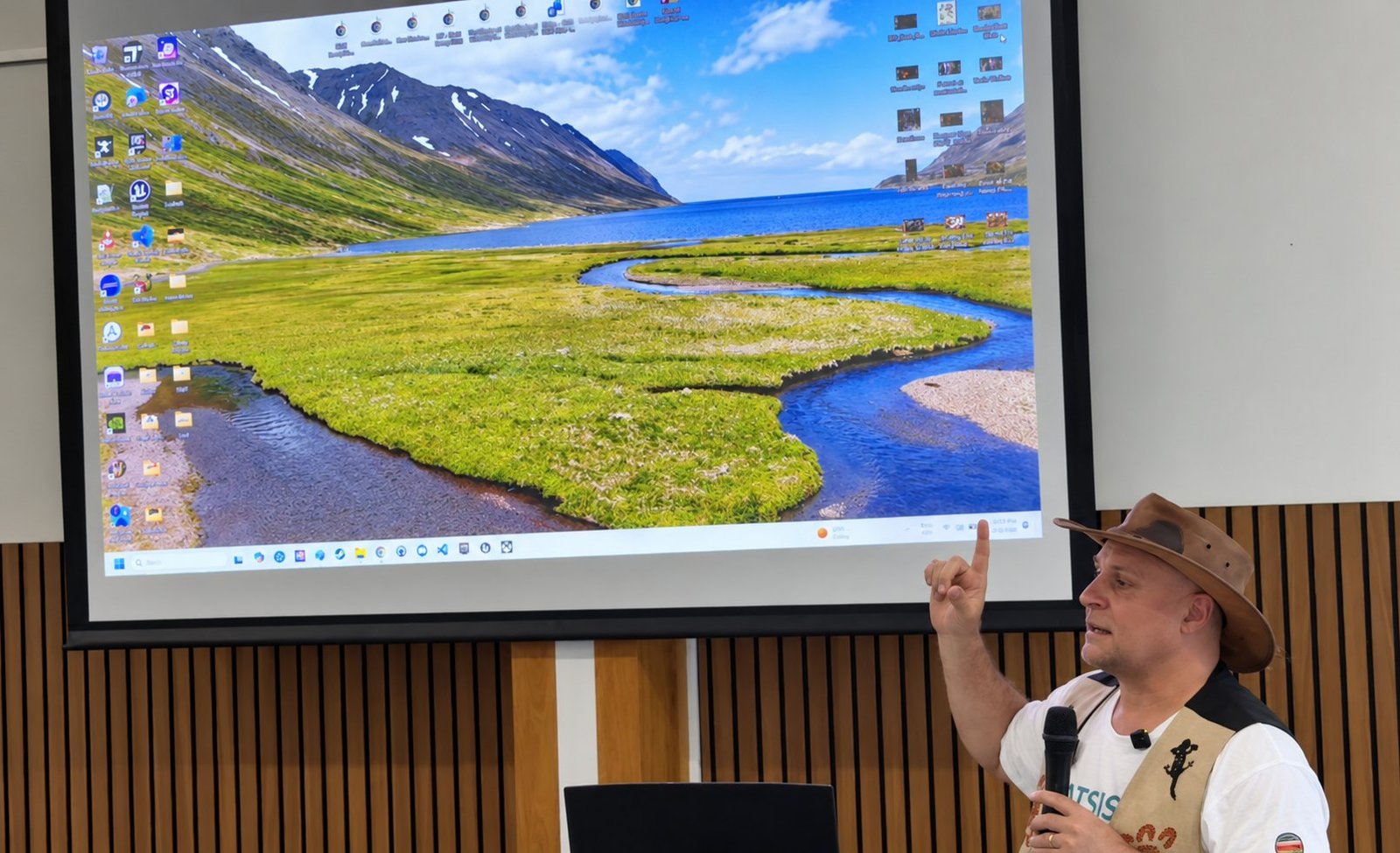 Brett Leavy, microphone in hand, points to the projected screen as he answers a question at Mitchelton Library.